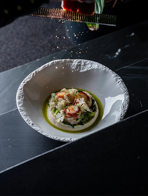 A refined dish of scallops with emulsion and crispy vegetables, served at the Dans le Noir ? restaurant